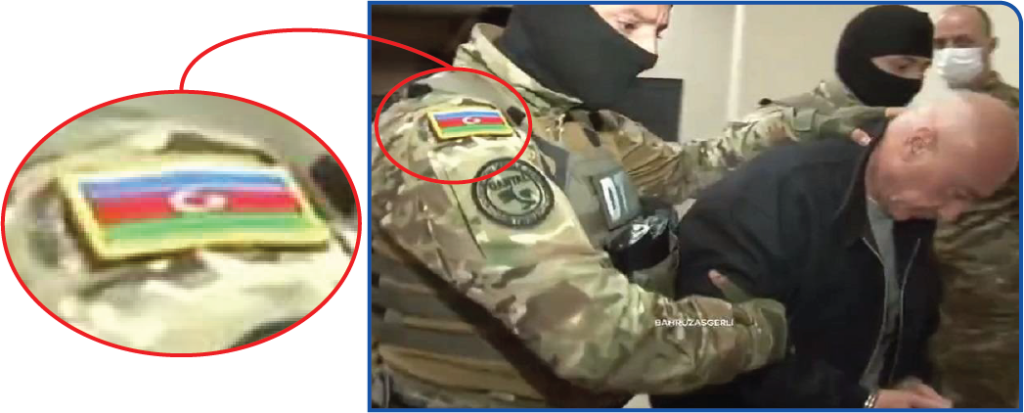 پرچمی که بر روی بازوی مأمور وجود دارد پرچم جمهوری آذربایجان است.